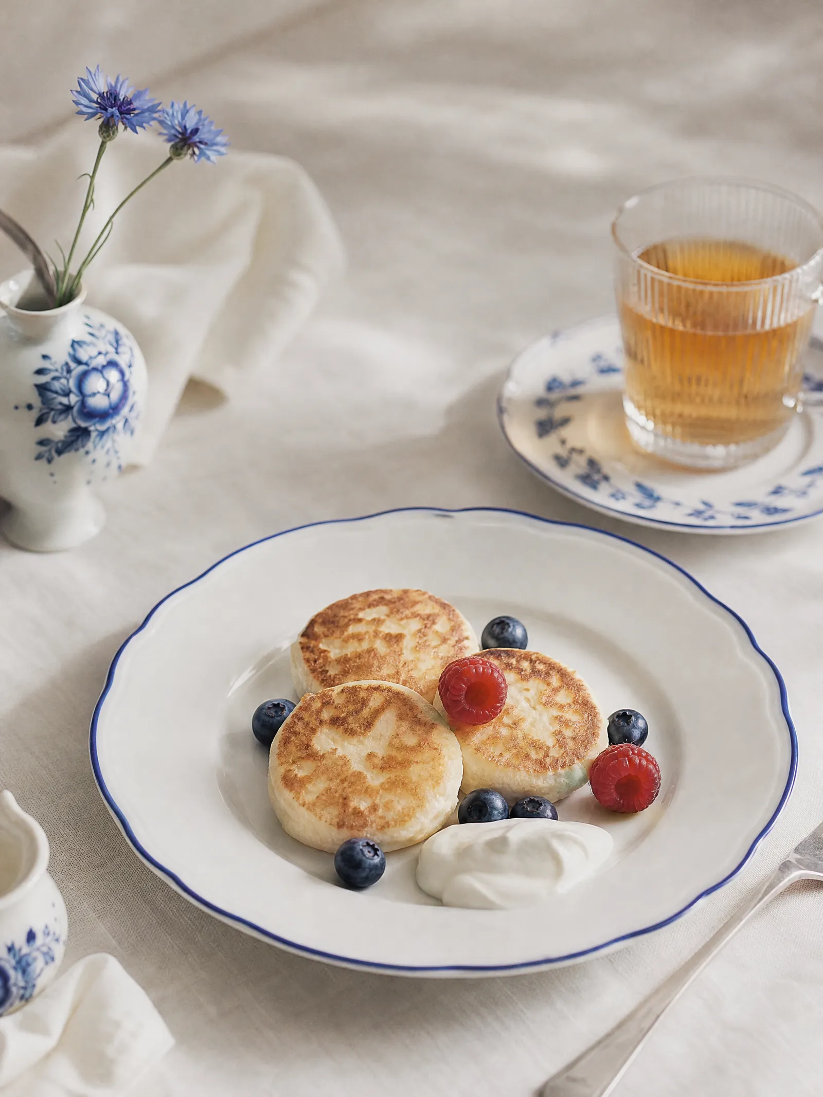 Syrniki with berries on a Gzhel plate